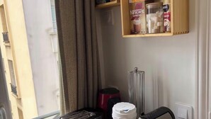 Une petite cuisine équipée d’un grille-pain, d’une machine à café et d’une bouilloire, le tout posé sur un plan de travail en bois.