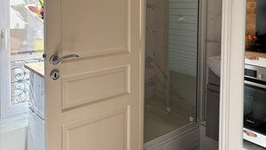 Une salle de bain avec une douche à parois en verre, des toilettes et un lavabo.
