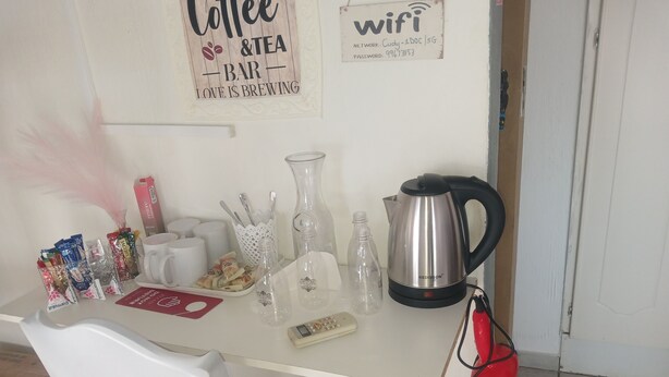 A kitchen counter with a coffee maker, mugs, and tea packets.