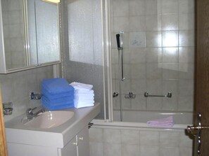 Ein Badezimmer mit Waschbecken, Spiegel und Duschbereich.