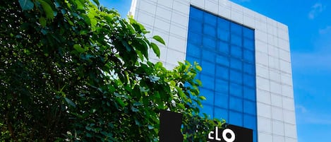 A modern building with a large glass window and a sign that reads 'cLO Served'.