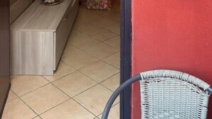 Ein Flur mit roter Wand, einer Holzbank, einem Korbsessel und einem Schild mit der Nummer 1.