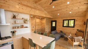 A wooden cabin interior with a kitchen, dining area, and living space. - Scandinavian Cabin on Sandy Lakefront [NEW RENOVATION] (Lake Ann)