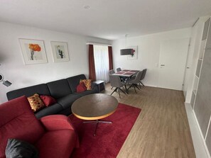 A modern living room with a sofa, a round coffee table, and a dining area with chairs and a table. - Valère C 211 # 6-bed apartment, Dusche, WC 6-Bettwohnung, Dusche, WC by Interhome (Leukerbad)
