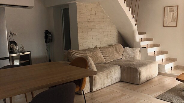 A modern living space with a dining area, a sofa, a staircase, and a kitchen. - A comfortable home between Aix-en-Provence, Marseille, and the Côte Bleue (Saint-Victoret)