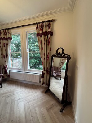 A room with two windows, a radiator, a mirror, and a chair. - O Romeo Suite at Elmwood House (Nottingham)