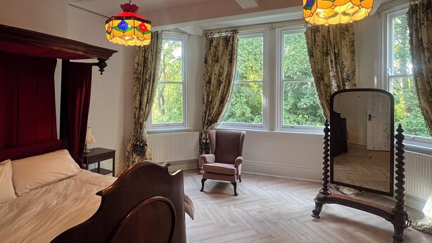 A room with a bed, a chair, a mirror, and two stained glass lamps. - O Romeo Suite at Elmwood House (Nottingham)