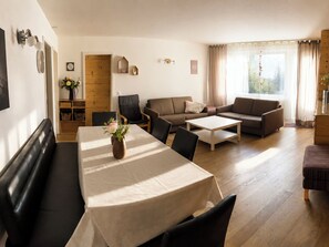 A living room with a dining table, sofas, and a wooden floor. - Majesta Leukerbad # 6-bed apartment, Dusche, WC by Interhome (Leukerbad)