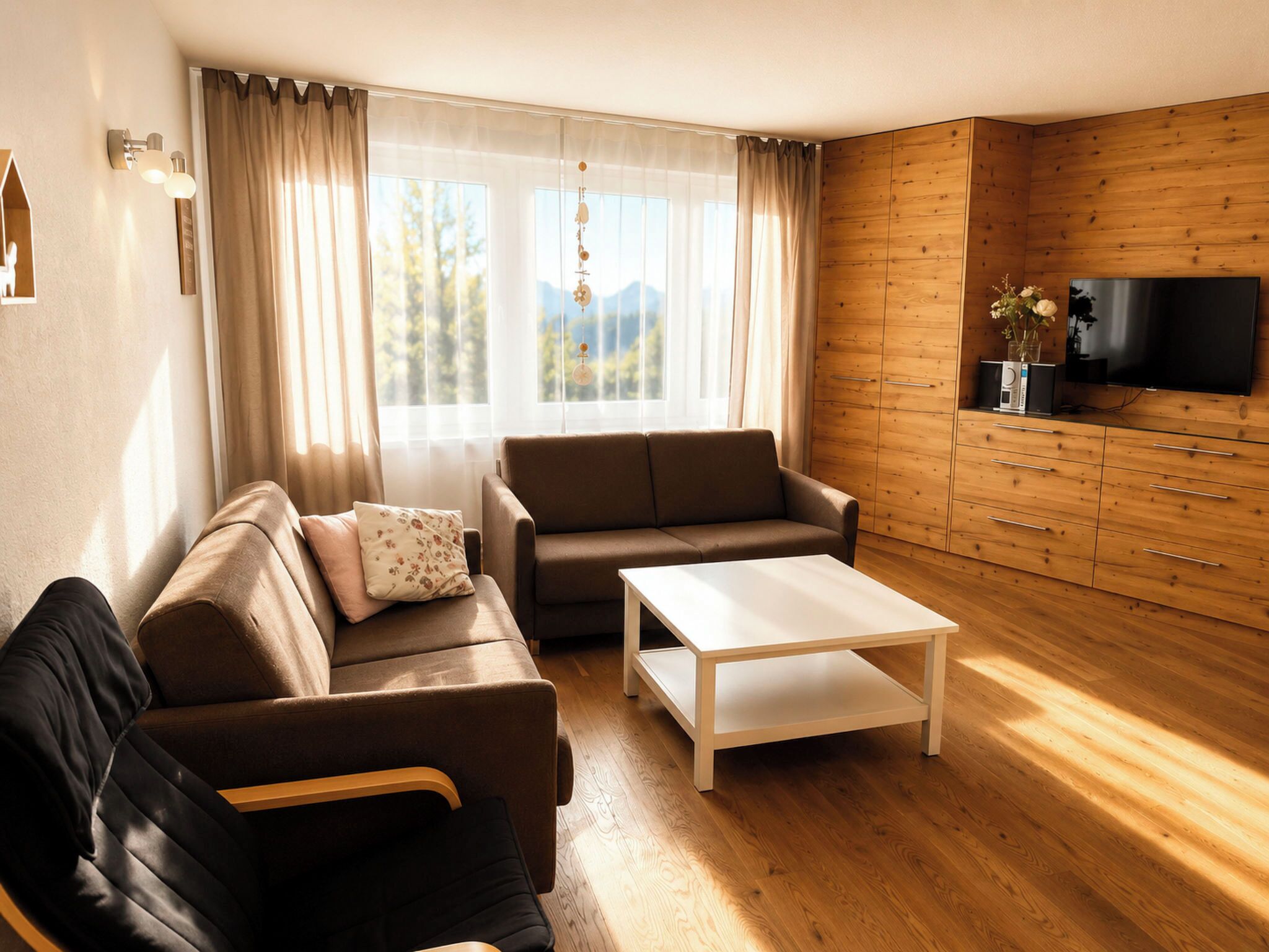 Ein modernes Wohnzimmer mit einer Couch, einem Couchtisch und einem Fernseher an einer Holzwand.