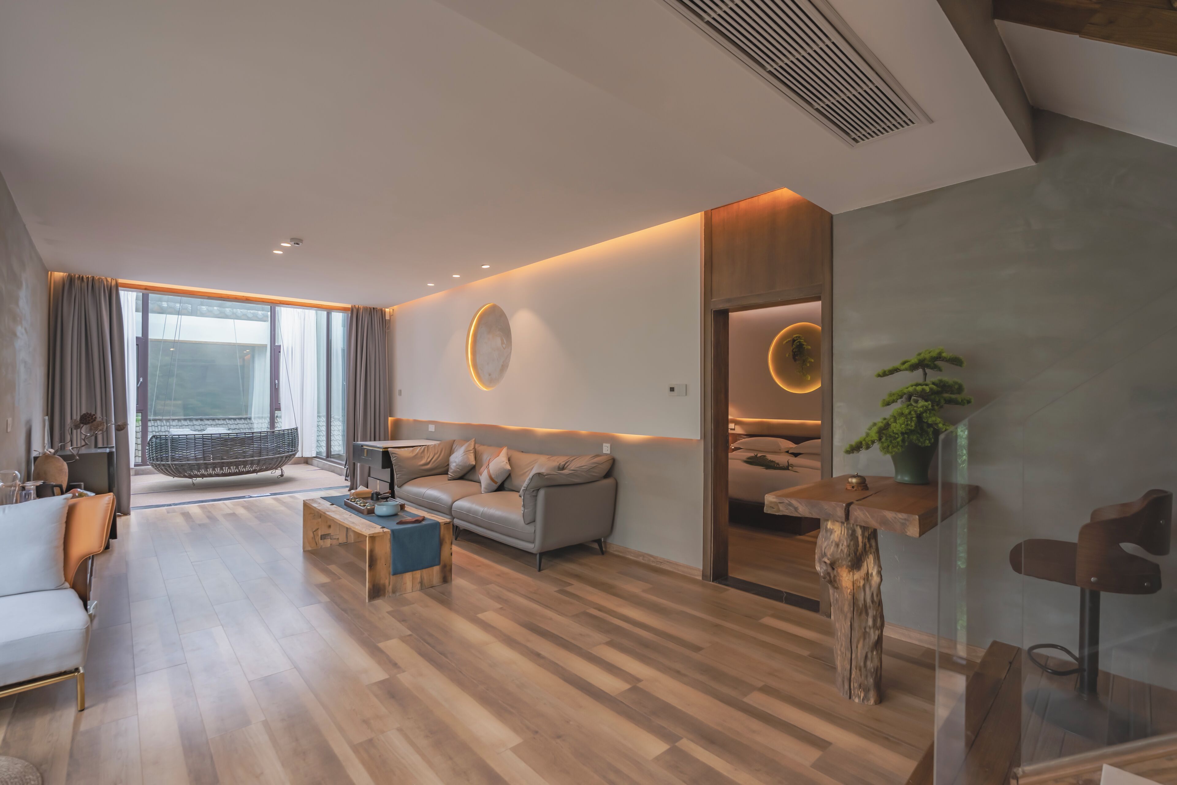 Una sala de estar moderna con un sofá, una mesa de centro y un ventanal grande.