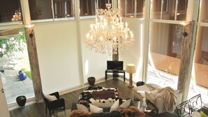 A spacious living room with a large chandelier, a sofa set, and a glass coffee table. - adfontes Ferien- & Wellnessappartements, (Bad Ragaz), by Interhome (Bad Ragaz)
