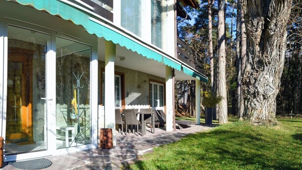 A modern house with a covered patio, stone flooring, and a grassy lawn. - Rothmund, (Bad Ragaz), by Interhome (Bad Ragaz)