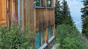 A modern wooden cabin with large windows, surrounded by lush greenery and a clear sky. - Casa Mia Pardiel, (Bad Ragaz), by Interhome (Bad Ragaz)
