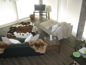 A living room with a sofa, a coffee table, and a television. - adfontes Ferien- & Wellnessappartements, (Bad Ragaz), by Interhome (Bad Ragaz)