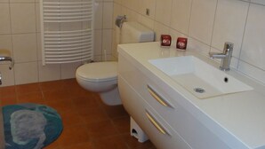 Un baño con inodoro, lavabo y espejo.