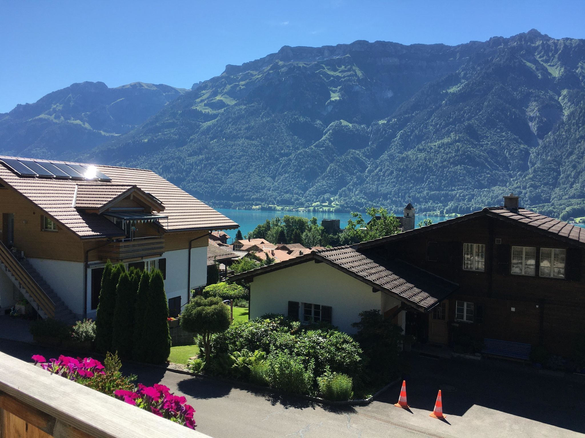 Um bairro residencial com casas, vista clara para um lago e montanhas ao fundo.