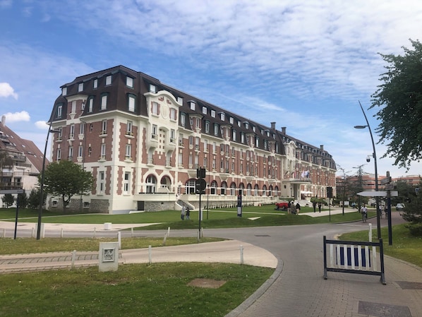 A large, multi-story hotel with a classic architectural style, featuring a prominent entrance and a well-maintained lawn area.