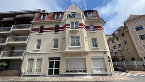 Un immeuble à plusieurs étages doté de balcons, de grandes fenêtres et d’une porte de garage.