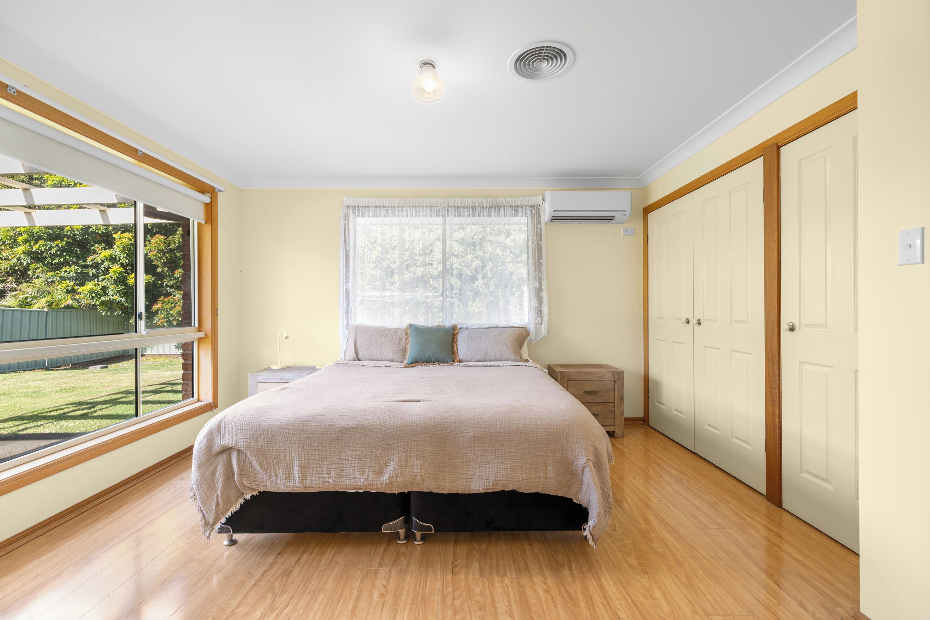 Een slaapkamer met een groot bed, een raam met uitzicht, een kledingkast en een airconditioning.