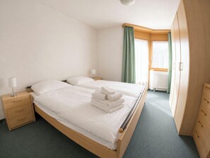 Ein Hotelzimmer mit einem Doppelbett, zwei Nachttischen mit Lampen, einem Kleiderschrank und einem Heizkörper.