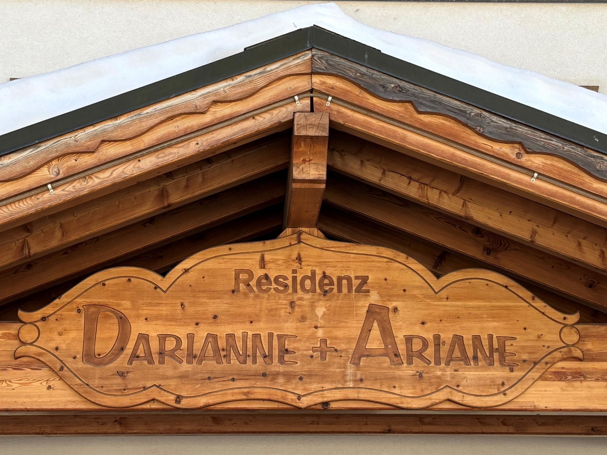 Un cartello di legno con il nome 'DARIANNE + ARIANE' e la parola 'Residenz' sopra.