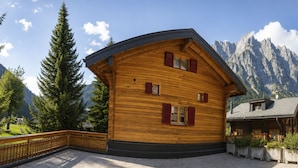 A wooden chalet with a balcony, set against a mountainous backdrop. - Residenz Darianne Leukerbad # 5-bed apartment, Dusche und Bad, WC by Interhome (Leukerbad)