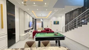 Een moderne woonkamer met een pooltafel, een bank en een televisie.