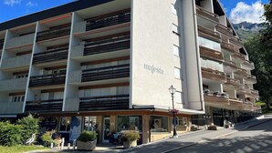 Un edificio de varios pisos con balcones, un letrero que dice 'majesta', y una calle al frente.