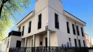 A modern building with a flat facade, multiple windows, and a metal fence. - Chic Madrid Stay With Terrace (Madrid)