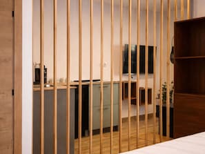 A room with a bed, a desk with a computer, a TV, and a kitchenette. - Chic Madrid Stay With Terrace (Madrid)
