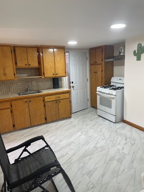 A kitchen with wooden cabinets, a white stove, and a tiled backsplash.