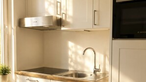 Een moderne keuken met witte kasten, een roestvrijstalen spoelbak en een Bosch oven.