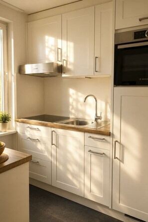 A modern kitchen with white cabinetry, a stainless steel sink, and a Bosch oven. - Majesta Leukerbad # 6-bed apartment, Dusche und Bad, WC by Interhome (Leukerbad)