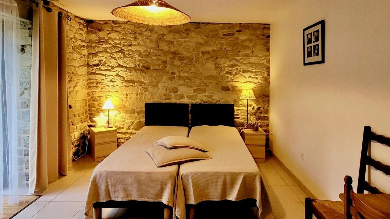 Ein Schlafzimmer mit Stehwand, einem Bett mit zwei Kissen, zwei Nachttischen mit Lampen und einem Holzstuhl.