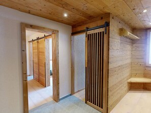 A wooden interior with a sliding door and a bench. - Apartment Skyline 406 by Interhome (St. Moritz)
