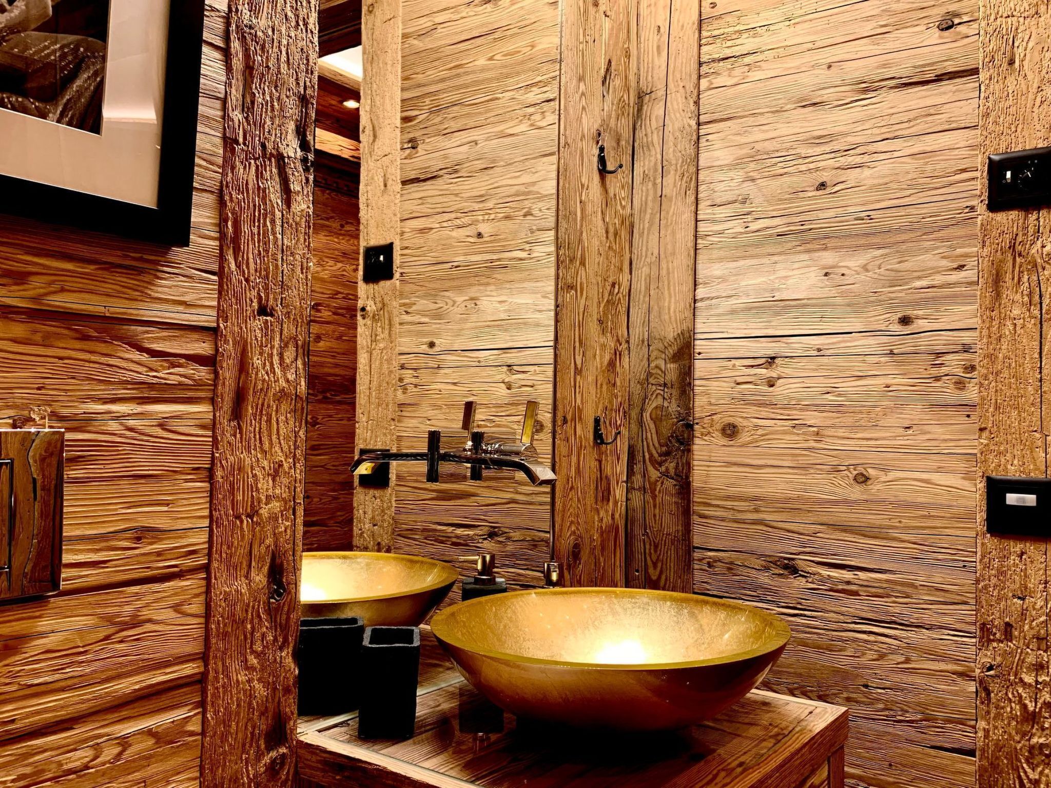 A bathroom with wooden paneling, two sinks, and a mirror.