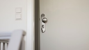 Une porte fermée, dotée d’une poignée métallique et d’un trou de serrure.
