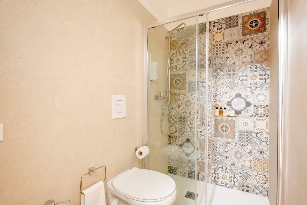 Ein Badezimmer mit Duschkabine, Toilette und Handtuchhalter.