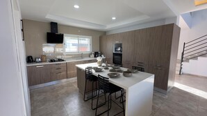 Una cocina moderna con una isla central, armarios de madera y horno empotrado.