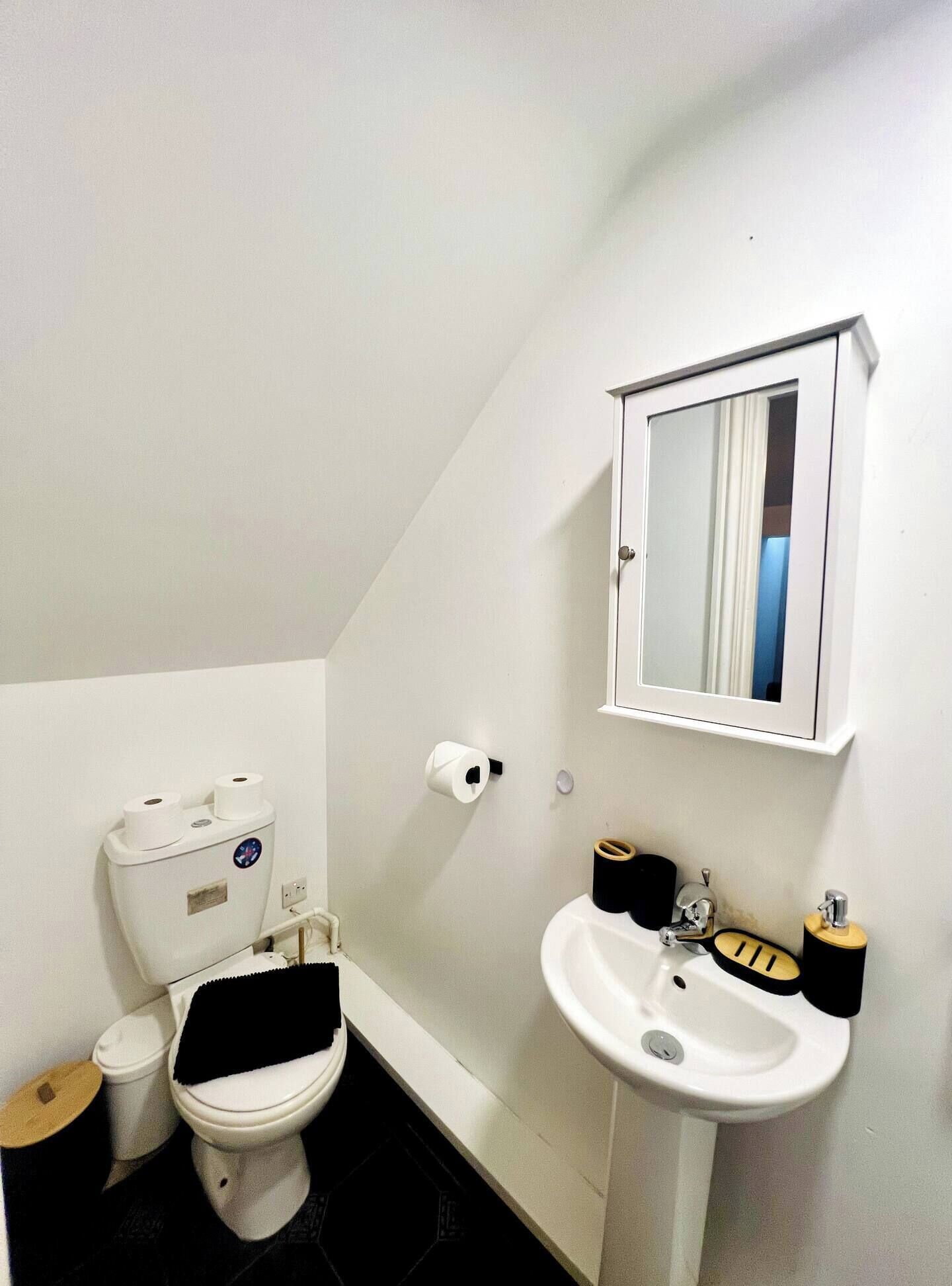 Un baño pequeño y blanco con inodoro, bidé y lavamanos.