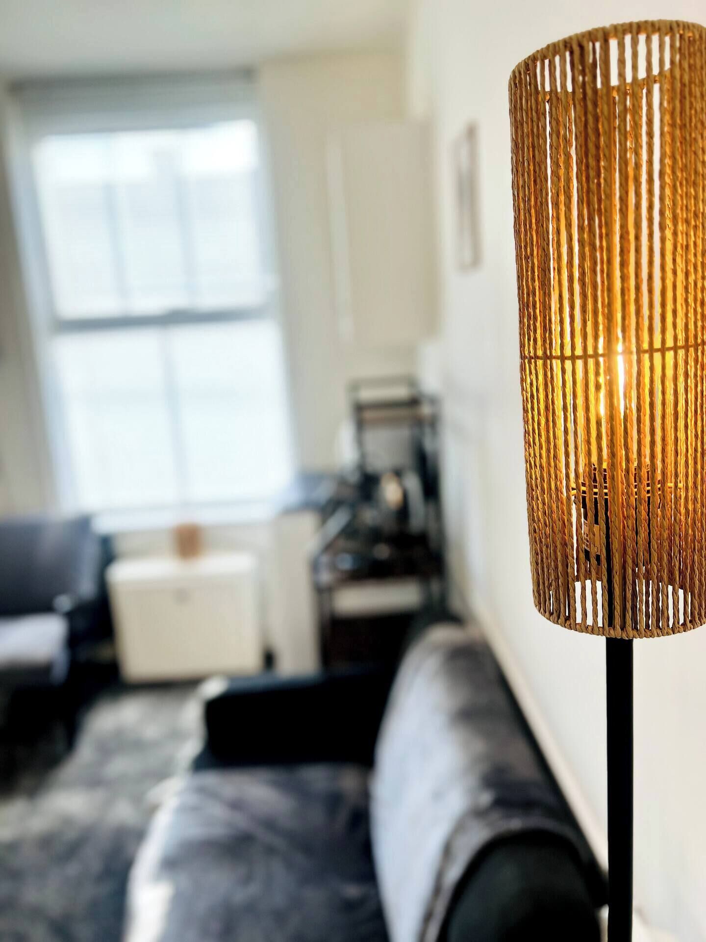 A modern living room with a sofa, a coffee table, and a lamp.