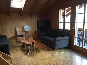 A wooden interior with a sofa, a table, and a TV. - Schwizi's Holiday Apartments Appartement/Fewo, Bad, WC, 2 Schlafräume No. 05 by Interhome (Ringgenberg)