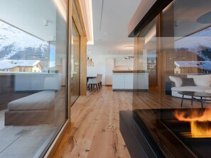 A modern interior with a kitchen, dining area, and a fireplace. - Apartment Mira Lej by Interhome (St. Moritz)