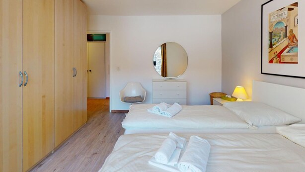 Ein Hotelzimmer mit Bett, Kleiderschrank, Spiegel und einem gerahmten Bild an der Wand.
