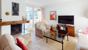 Ein Wohnzimmer mit Kamin, Fernseher und einer Couch.