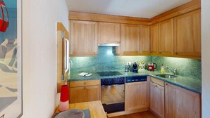 Una cocina funcional con armarios de madera, lavavajillas y encimera de granito.