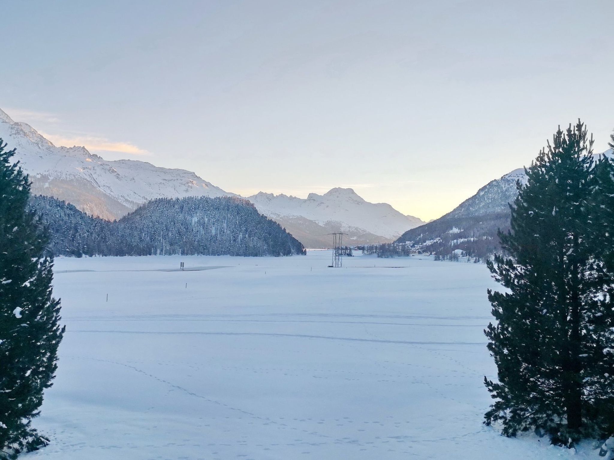A snowy landscape with mountains and a clear sky.
