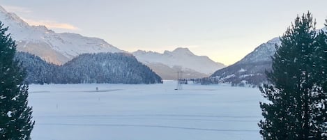 A snowy landscape with mountains and a clear sky.