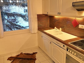 A kitchen with a window, a sink, cabinets, and a stove. - Apartment Muntagna Alva OG by Interhome (St. Moritz)