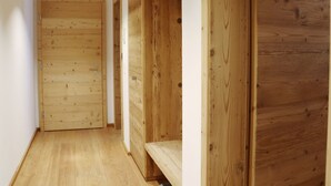 Un pasillo estrecho con paredes y puerta de madera al final.